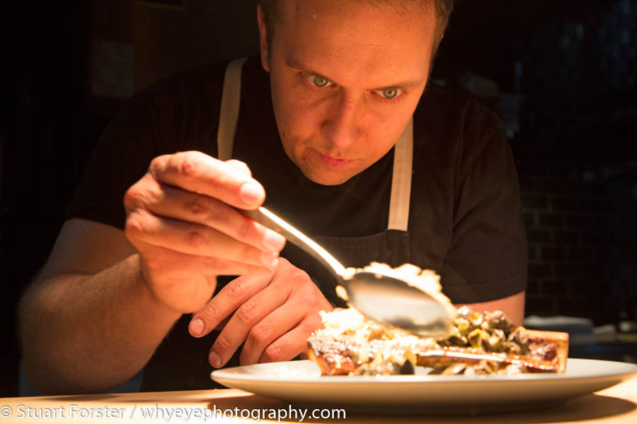 Chef Darren MacLean concentrating while putting the finishing touches to one of his dishes at Shokunin in Calgary, Alberta
