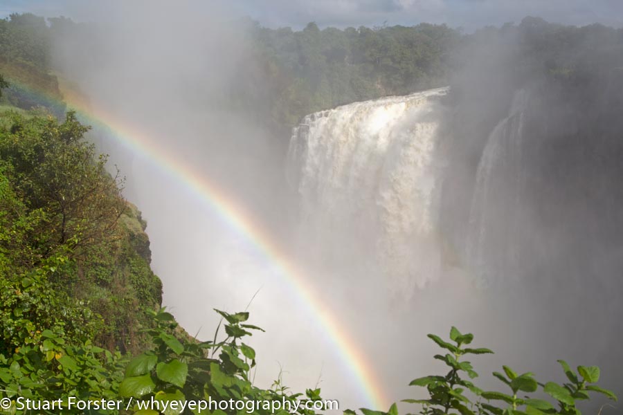 A rainbow in spray by the Victoria Falls waterfall (Mosi-oa-Tunya), one of the highlights of Zimbabwe travel photography.