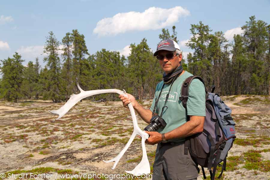 Dr Brian Kotak holding an antler while leading a guided nature walk on an esker in northern Manitoba.