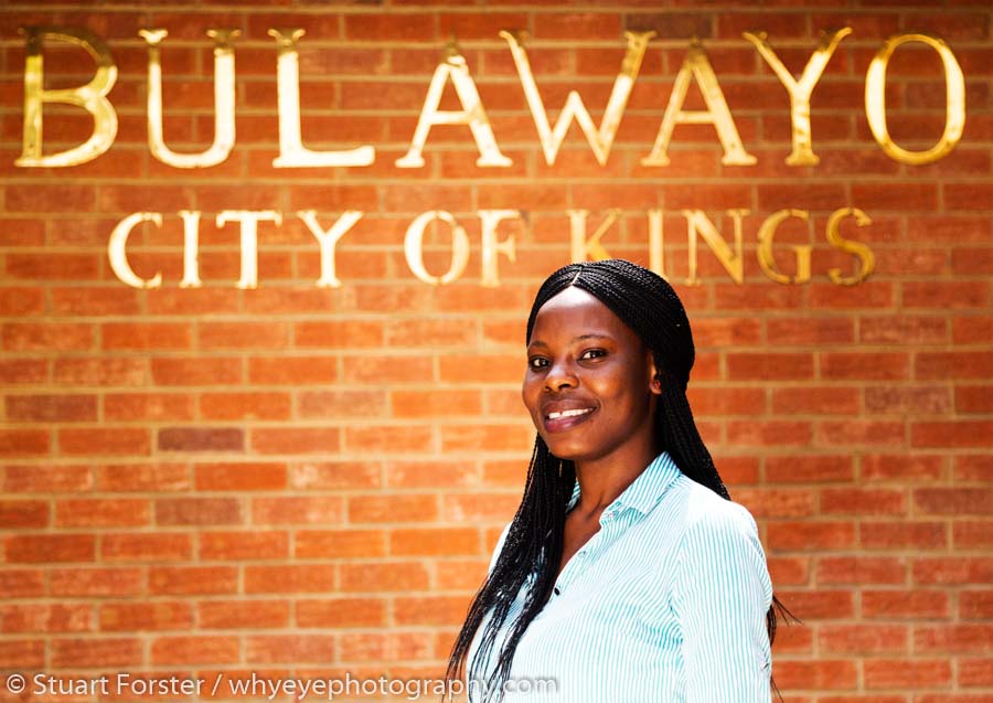 Woman by a 'Bulawayo City of Kings' sign.