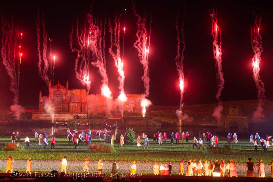 Fireworks burn red in the night sky during a scene from Kynren at Bishop Auckland