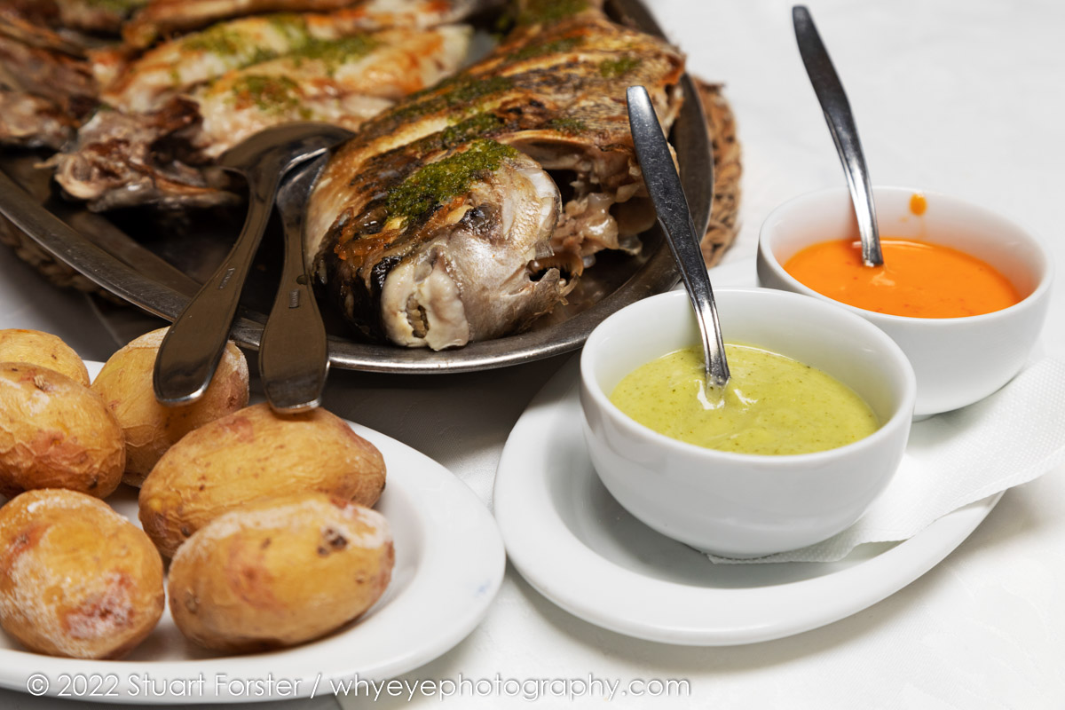 Wrinked potatoes (papas arrugadas) served with red sauce (mojo rojo) and green herby sauce (mojo verde) plus a platter of grilled fish at the Restaurante Régulo in Puerto de la Cruz, Tenerife.