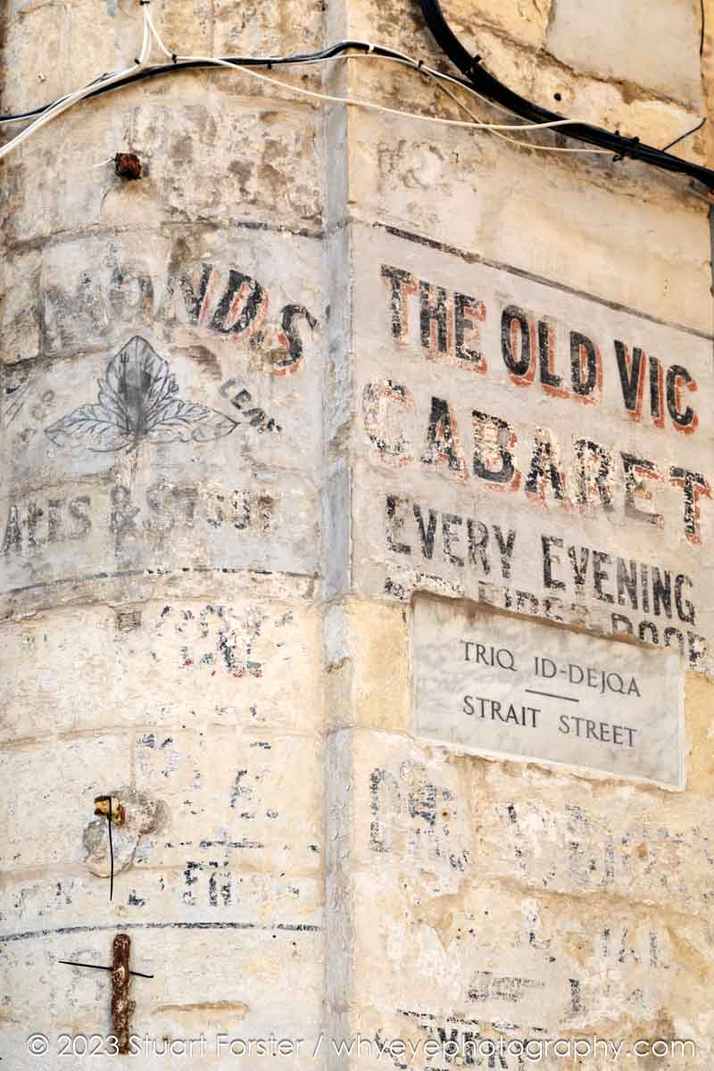 Faded signage on the wall of Strait Street, once an infamous area for bars frequented by sailors, in Valletta, Malta.