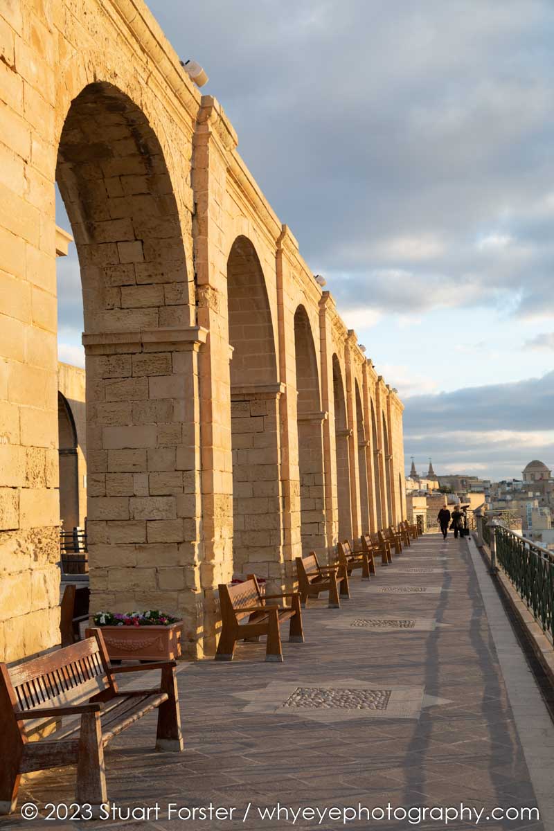 Stone arches and the promenade that overlooks the Grand Harbour in Valletta's Upper Barrakka Gardens, a popular tourist attraction in Malta.