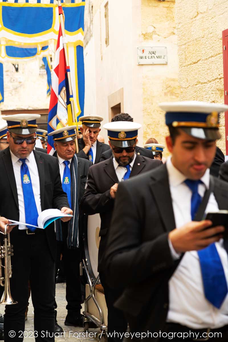 Band members check their phones and relax between playing tunes during a festa, a traditional Maltese festival, in Rabat.