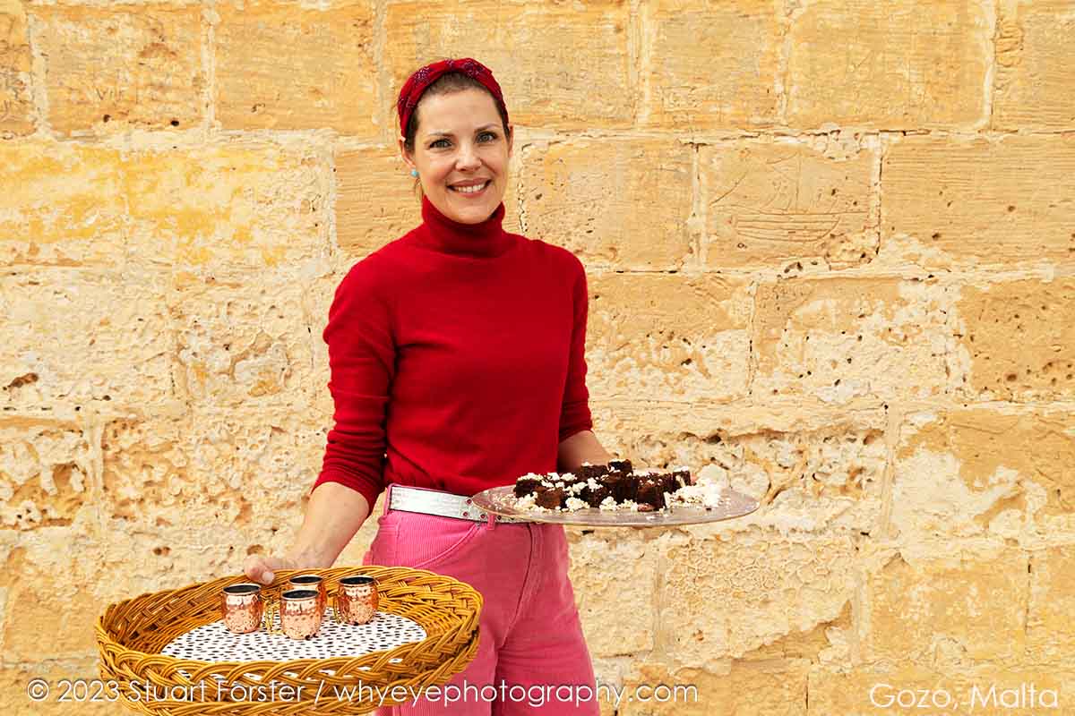 A smiling member of the Gozo Picnic team serving coffee and cake at the Cittadella in Gozo.